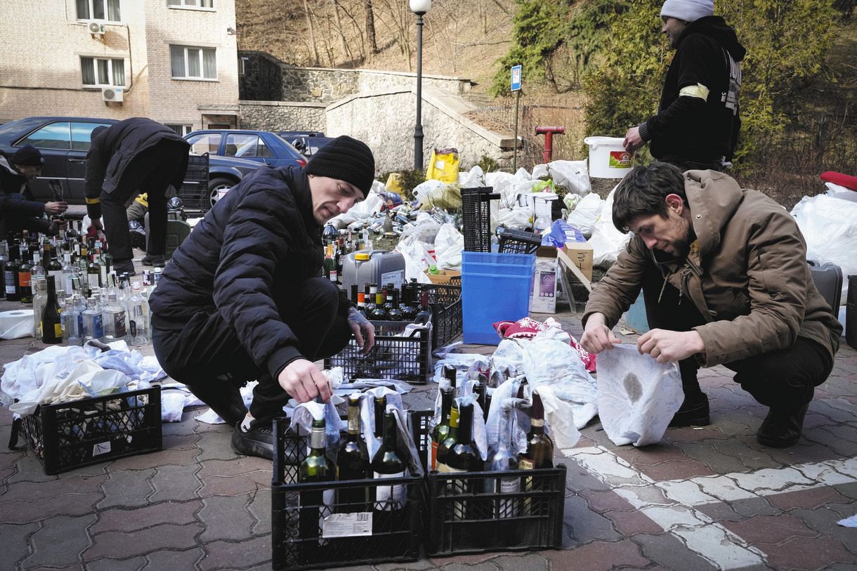  ウクライナを守ろうとキエフの庭で火炎瓶を準備する市民ら＝2022年2月27日（AP）