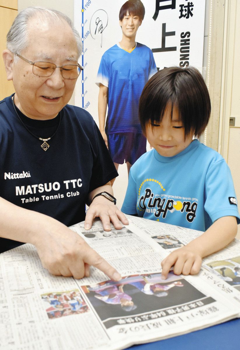 戸上選手の活躍を報じる中日新聞を広げる松生さん（左）と西川さん＝津市半田の松生卓球道場で

