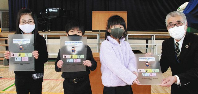 木村会長(右)からクリアファイルを受け取った児童ら=野洲市西河原の中主小で