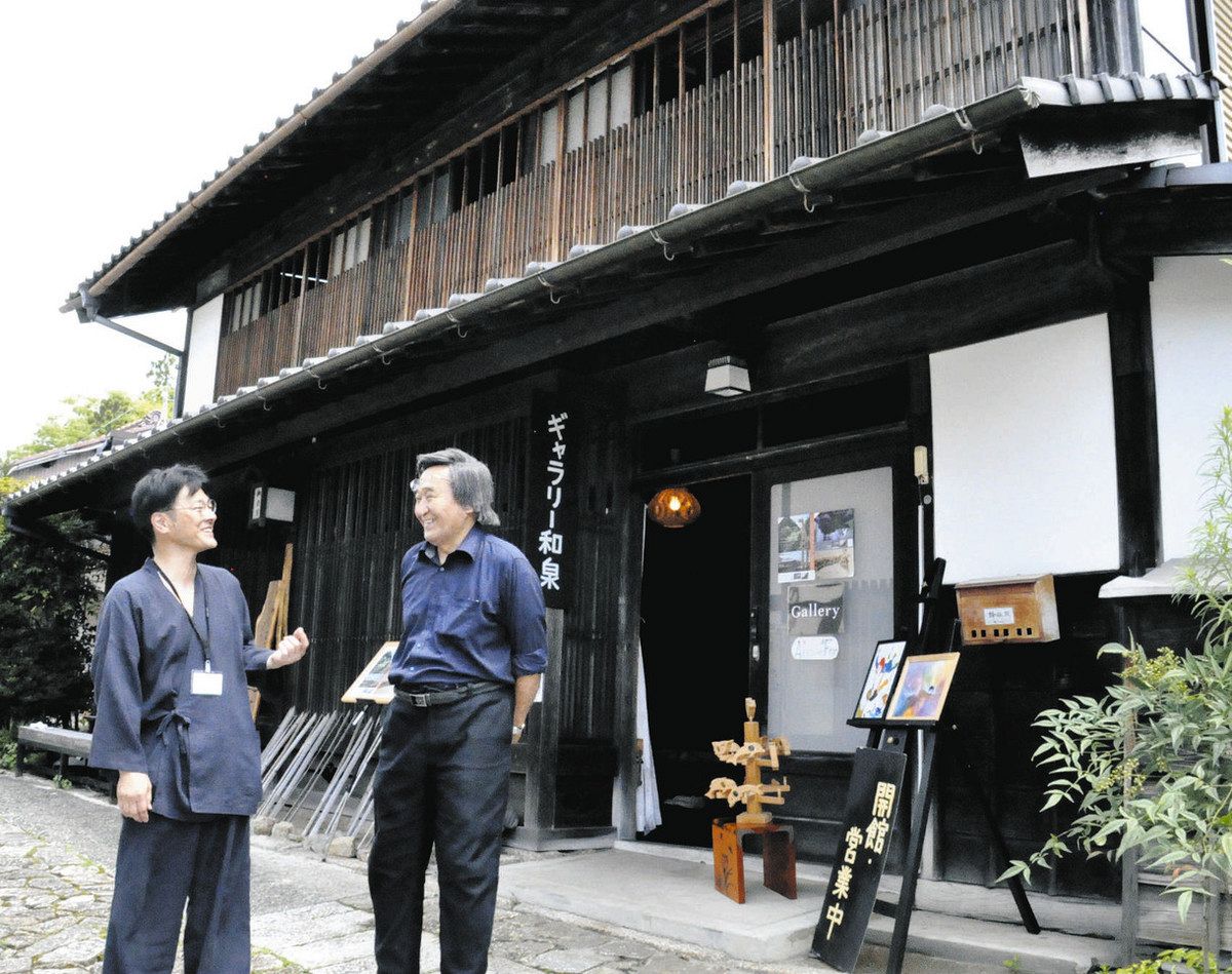 ギャラリー和泉の前でグランドオープンを喜ぶ蜂谷さん（左）と田中さん＝中津川市馬籠で