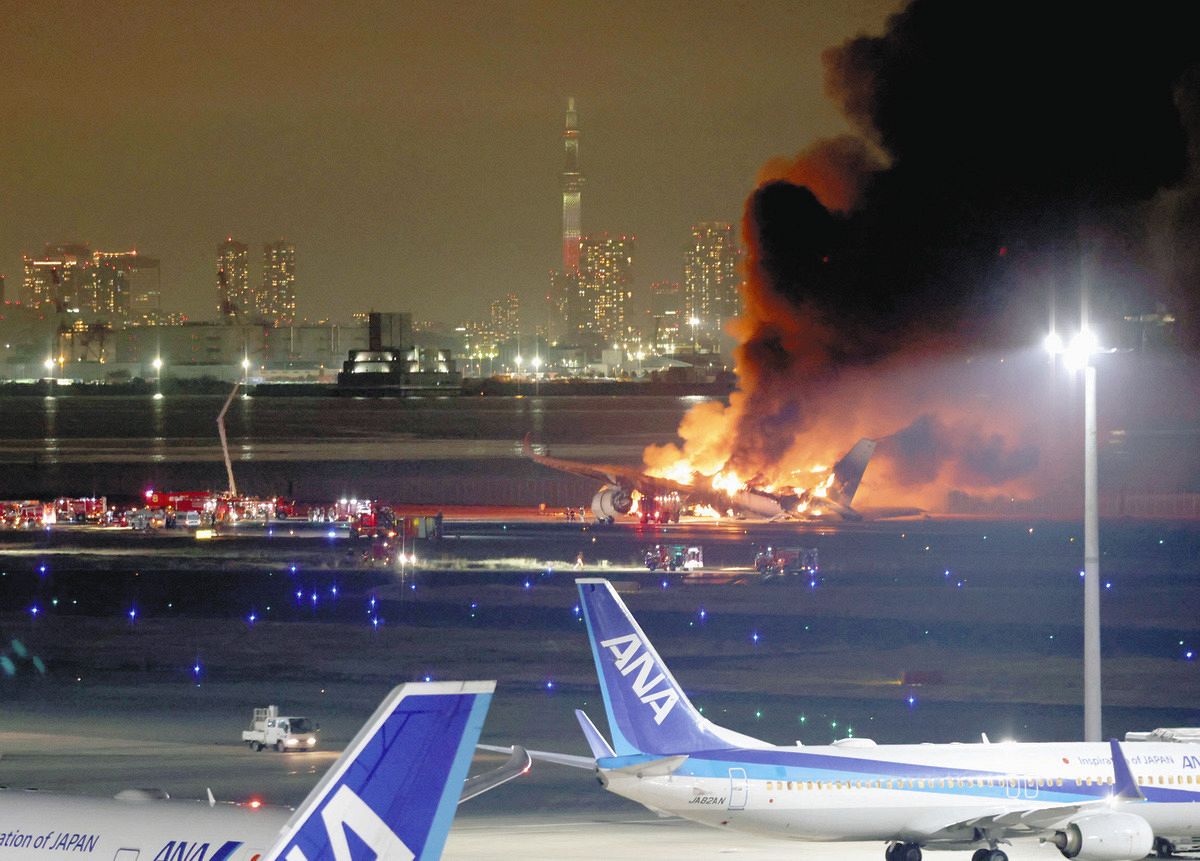 衝突事故で炎上する日航機。後方は東京スカイツリー