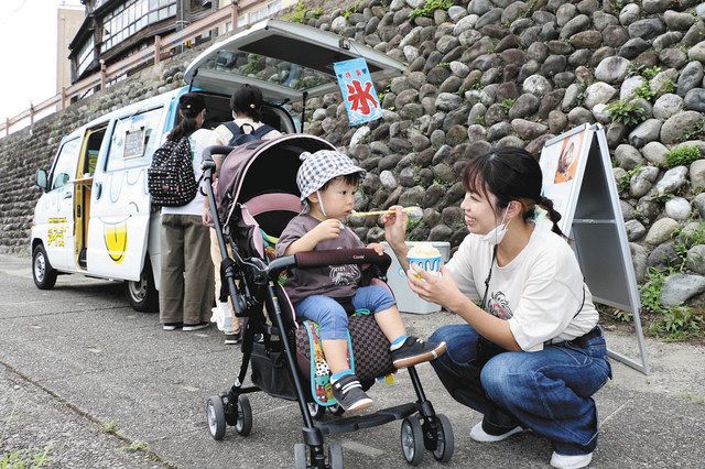 出店したキッチンカーで買ったかき氷を味わう親子連れ＝金沢市寺町で