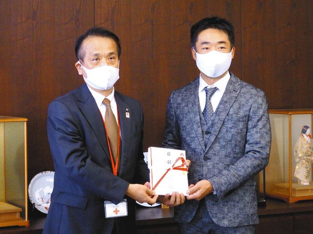 寄付金の目録を手渡した永井会長兼社長（右）と松田事務局長＝四日市市北浜田町のトヨタカローラ三重本社で 