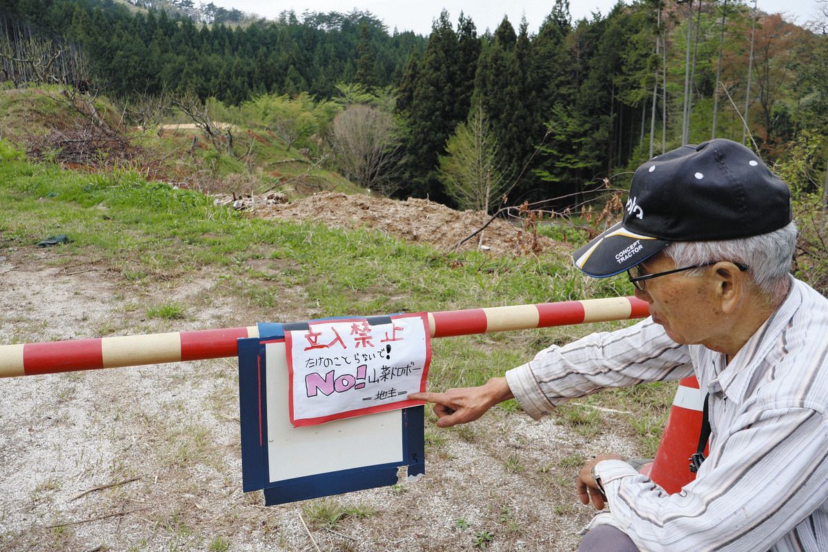 立ち入り禁止の張り紙をしている鈴木さん＝恵那市上矢作町で