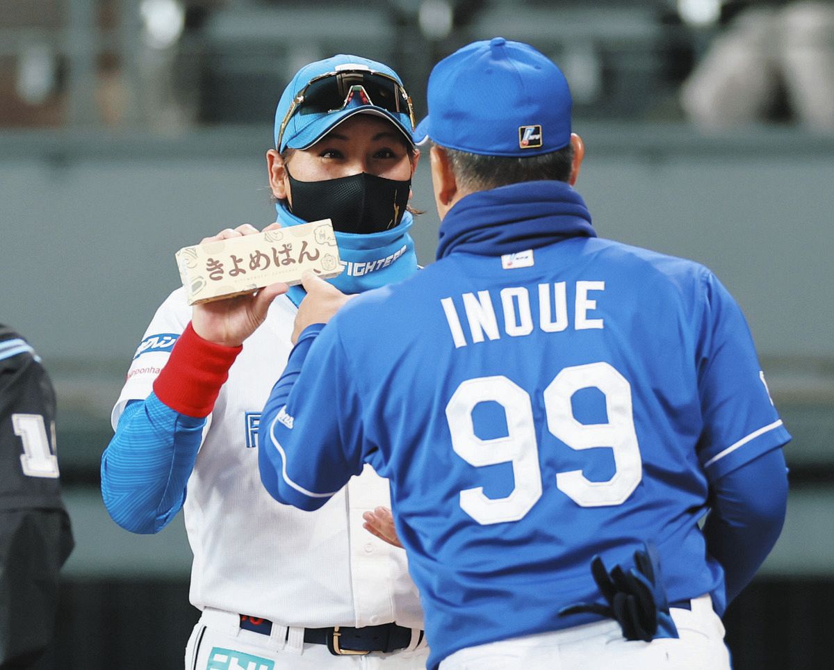 メンバー表交換で井上監督（手前）から「きよめぱん」をプレゼントされた日本ハム・新庄監督