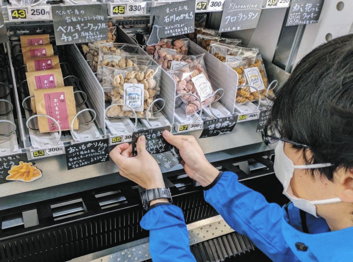 超短時間雇用で働き、自販機のポップを貼り替える男性＝同市で（コネル提供） 