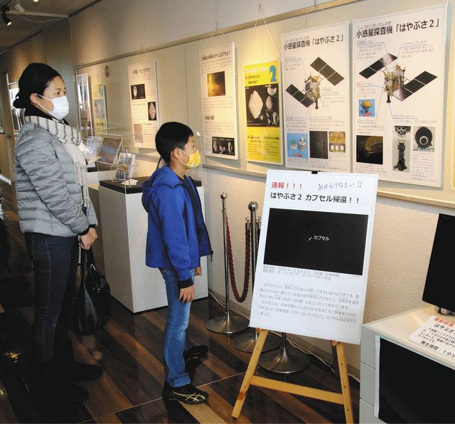 「はやぶさ２」に関する展示品を見る親子＝富山市西中野町の市科学博物館で 