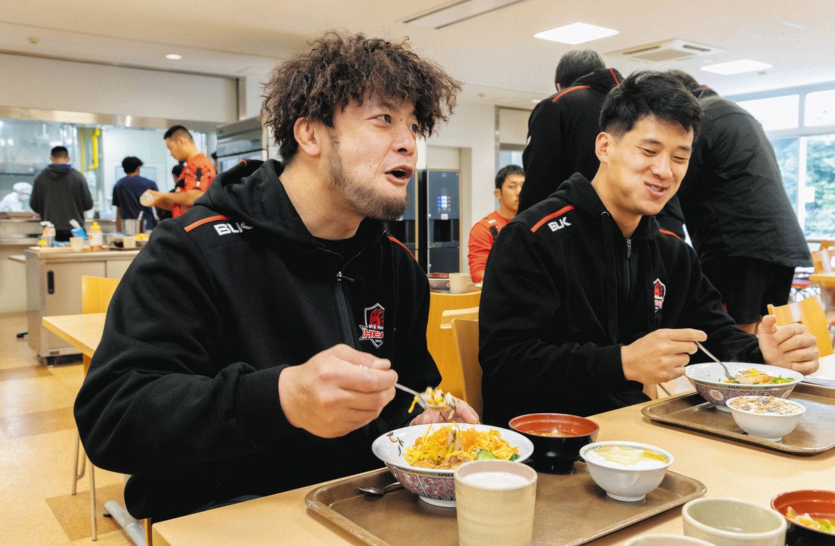 チームメートと昼食を食べるホンダヒートの秋山選手（左）＝鈴鹿市で