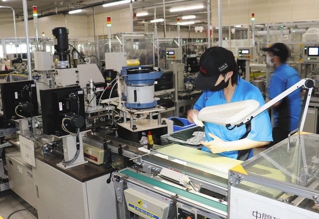 ラインを流れてくる分電盤の部品をチェックする従業員＝長久手市蟹原の日東工業で 