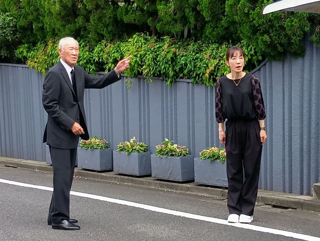 弔問に訪れた青木功さん㊧を見送る、喪主の長島三奈さん