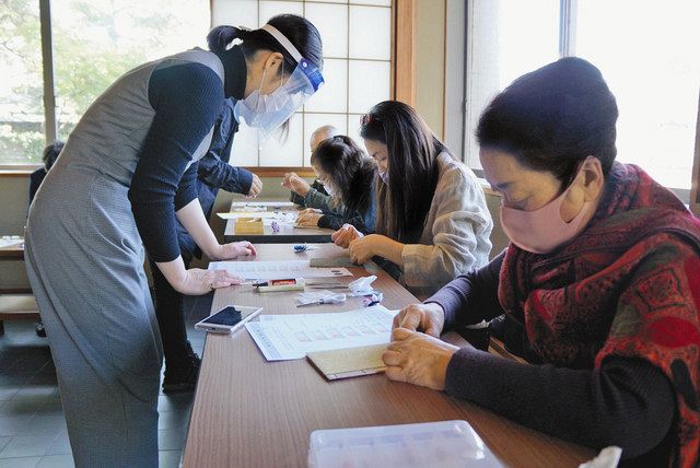 枕慈童の豆本を作る参加者ら＝金沢市兼六町で 