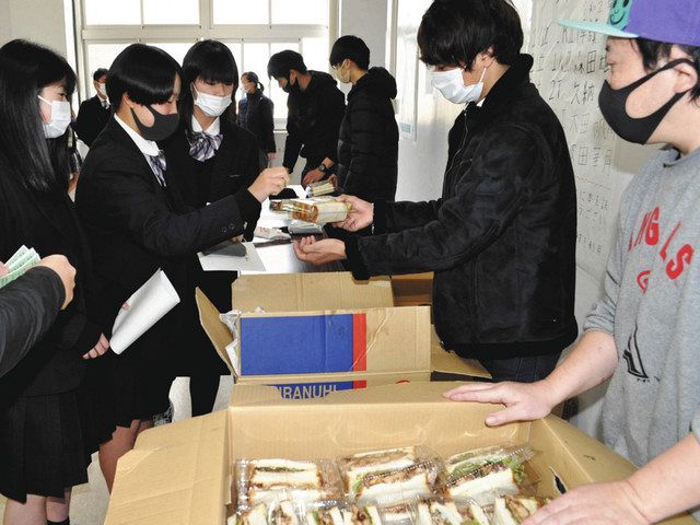 山賊焼のサンドイッチなどを販売する大学生と高見さん（右）＝塩尻市の都市大塩尻高で
