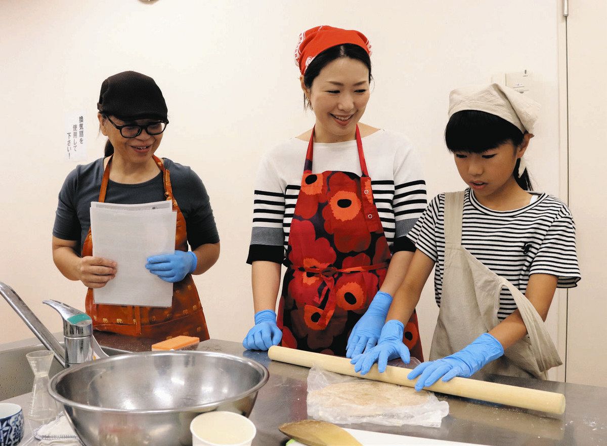 小麦粉で作った生地を麺棒で伸ばす参加者ら＝金沢市粟崎町の市ものづくり会館で 