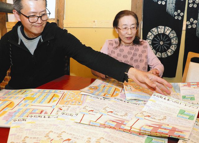 完成したロードマップを折り畳む丸山英邦さん（左）ら＝七尾市中島町藤瀬で　　