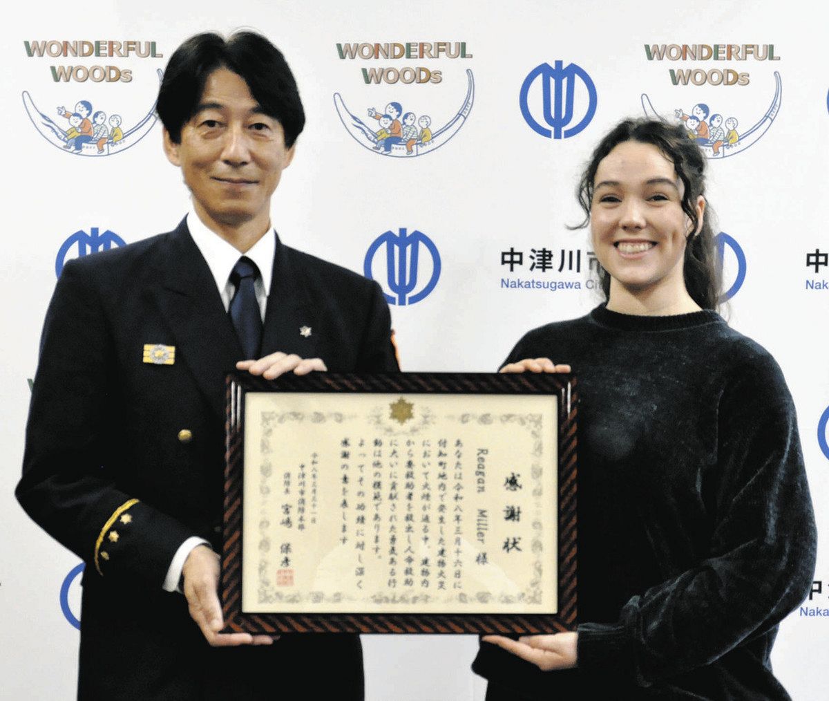 火災現場での救助の功績で宮嶋消防長から感謝状を受け取るミラーさん（右）＝中津川市の北消防署で