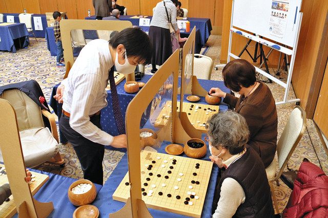 下島陽平八段（左）と対局を楽しむ参加者＝浜松市西区で 