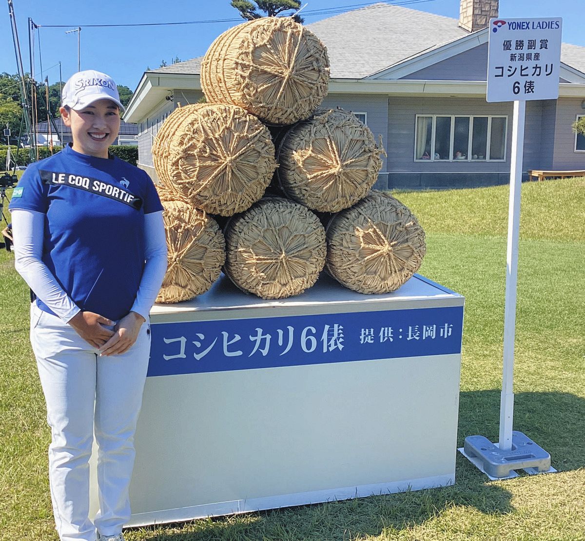 優勝副賞の米俵を前に笑顔を見せる小祝さくら