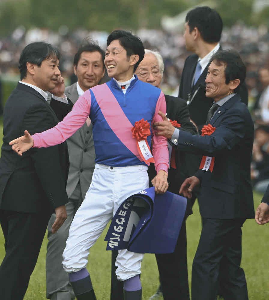 関係者と笑顔で握手する武豊（中央）と石橋守調教師（右）