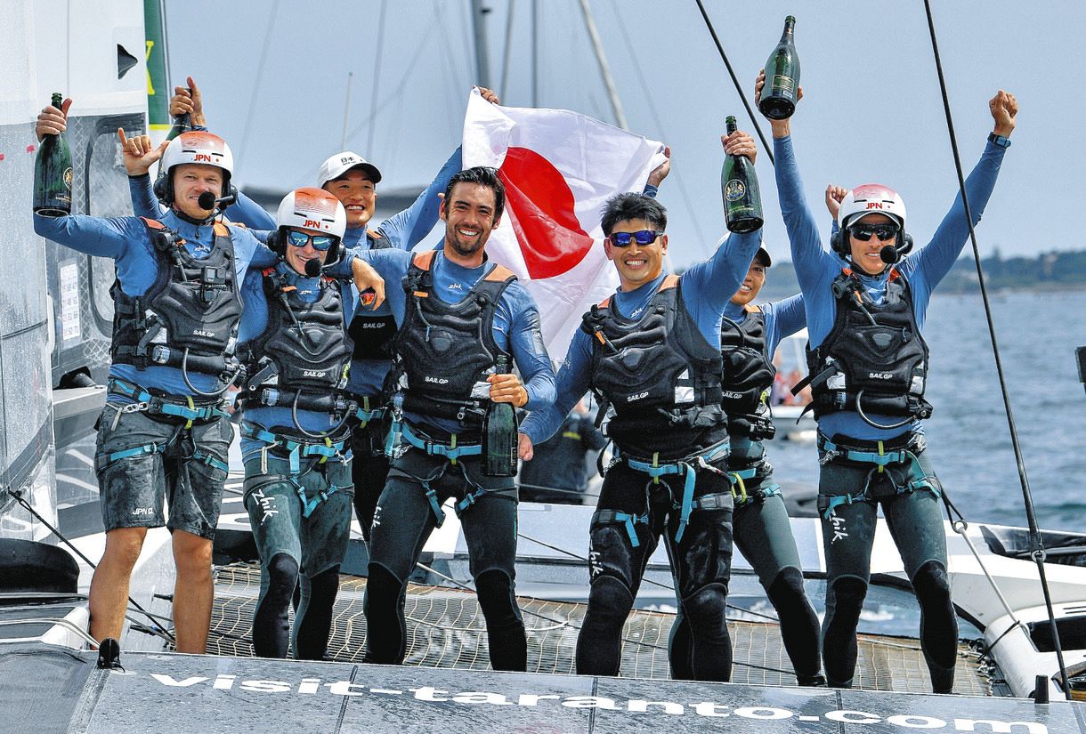 2021年スペイン大会で優勝し、シャンパンを手に喜ぶ日本チームと笠谷勇希（SailGP提供）