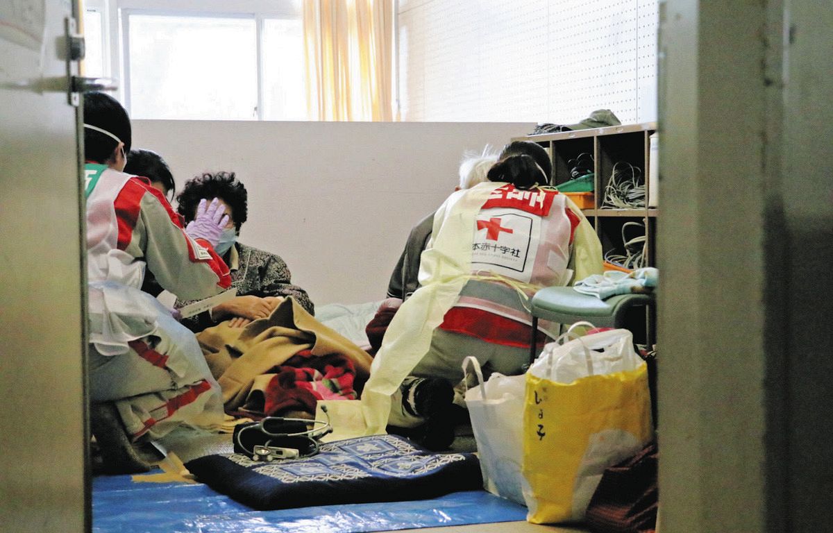 避難所となっている飯田小学校で問診する福井赤十字病院の医療チームの医師ら＝石川県珠洲市で