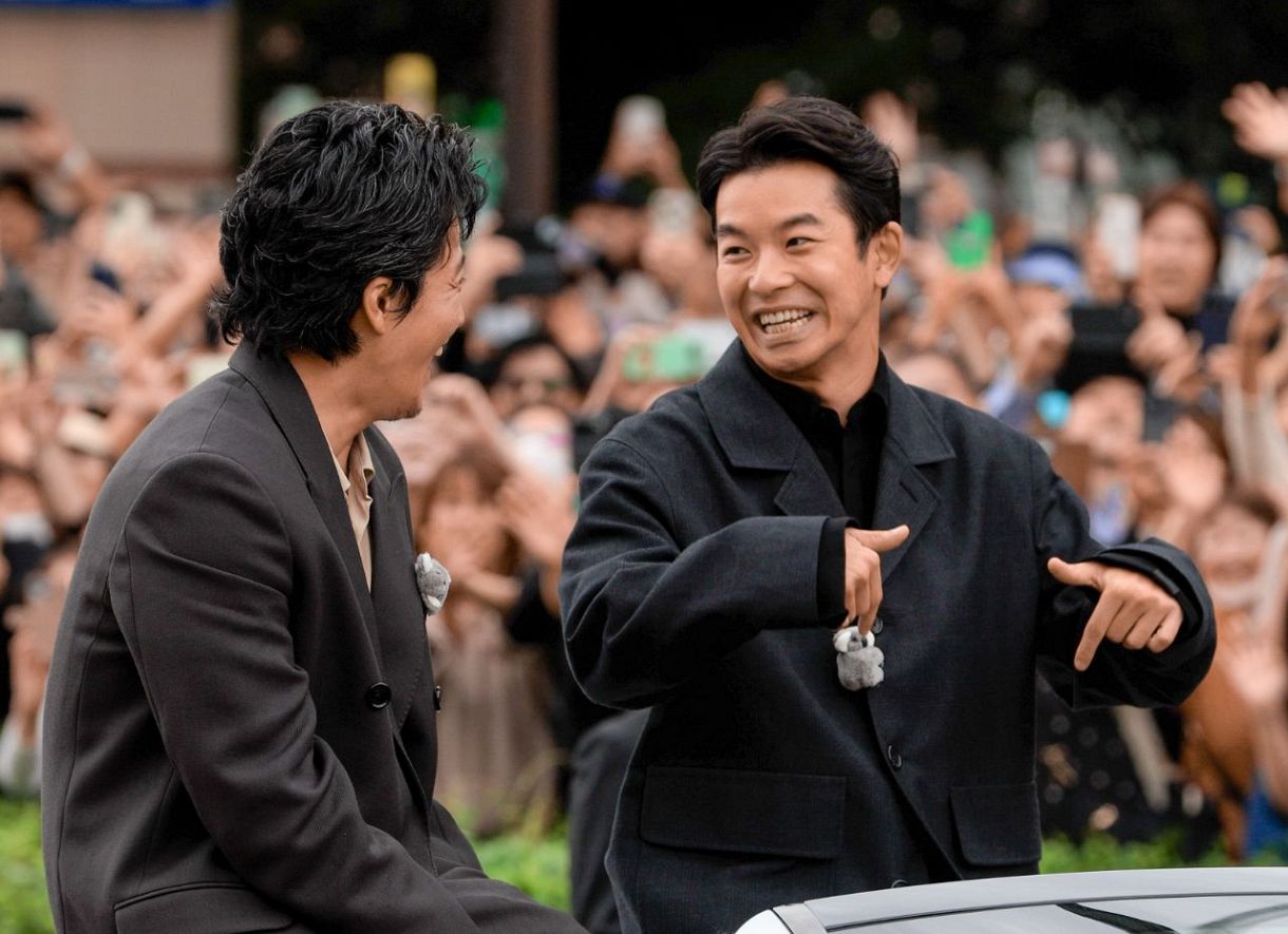 オープンカーの上で言葉を交わす俳優の仲野太賀さん㊨と小栗旬さん