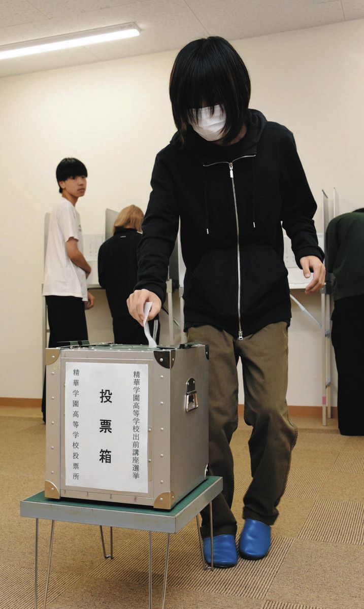 投票箱に投票用紙を入れる生徒＝多治見市本町で