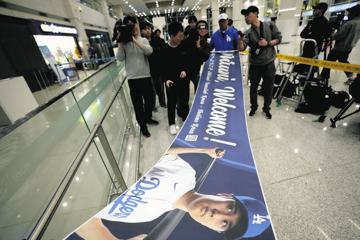 ドジャース到着を待つ韓国・仁川空港では大谷翔平の顔写真入りバナーを持つファンの姿も（AP）
