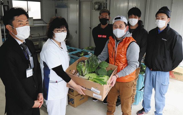 野菜を手渡す北野宏和さん（右から３人目）＝加賀市医療センターで 