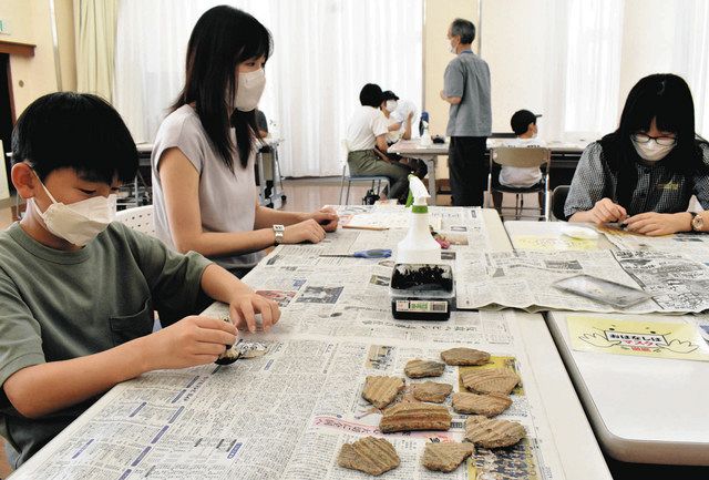 土器の模様を写し取る「拓本」に挑戦する参加者＝福井市のこども歴史文化館で