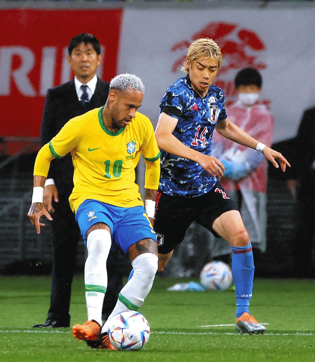 日本―ブラジル　前半、ネイマール（左）と競り合う伊東。後方は試合を見つめる森保監督
