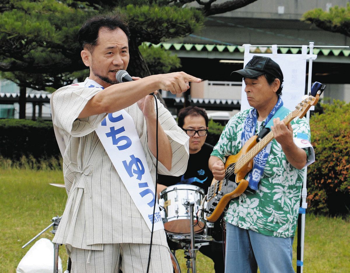西尾市長選でバンド演奏に乗せて主張を展開する安達祐さん＝2025年6月、愛知県西尾市の名鉄西尾駅前で
