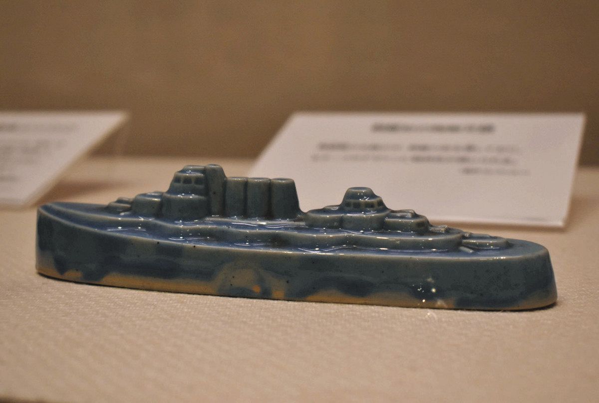 戦艦の形をした陶器製の文鎮＝津市の県総合博物館で