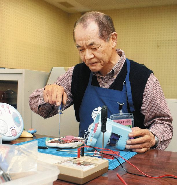 玩具の内部点検をする上木一郎さん=富山市今泉の市総合社会福祉センターで