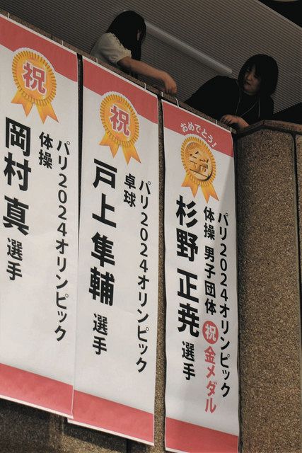 杉野選手の金メダルを祝う垂れ幕を掲げる市職員＝津市役所で
