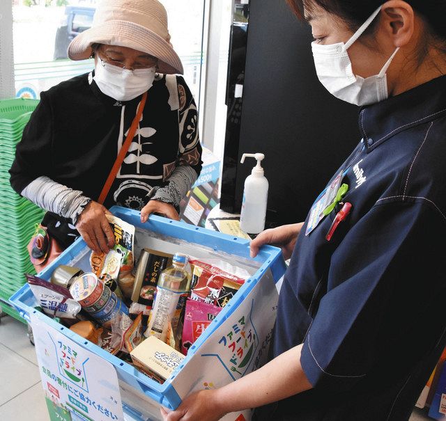 店員から集まった食料品を受け取る大沢さん（左）＝松川町上片桐のファミリーマートＪＡ上片桐店で 
