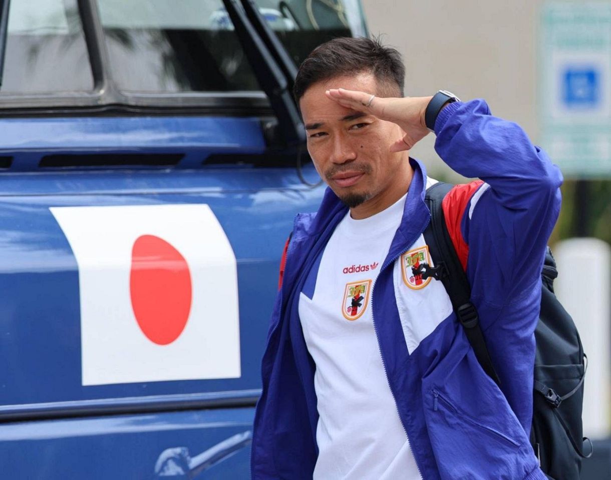 敬礼ポーズでバスに乗り込む長友