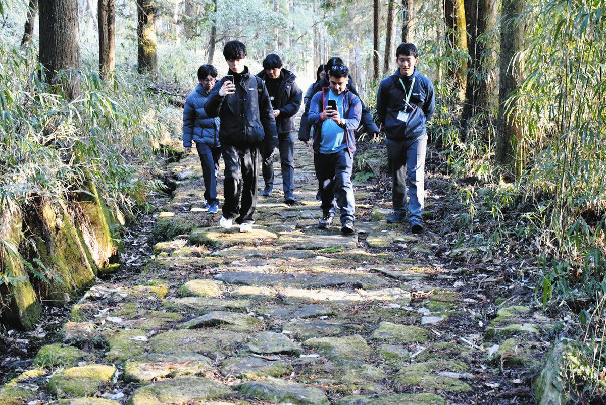 写真を撮りながら石畳を歩く旅行手配会社の担当者ら＝瑞浪市の琵琶峠で
