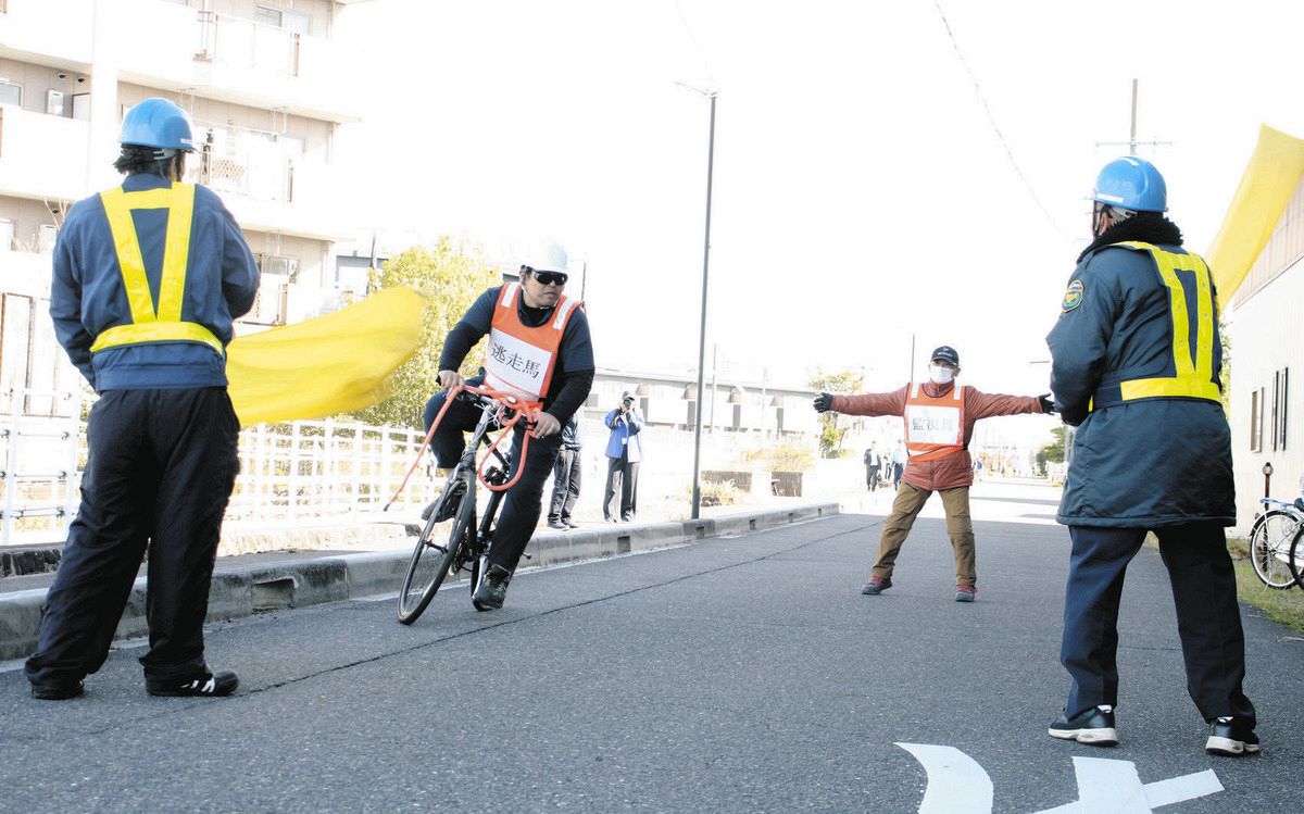 逃げ出した馬役（左から２人目）の確保手順を確認する警備員ら＝笠松競馬場周辺で