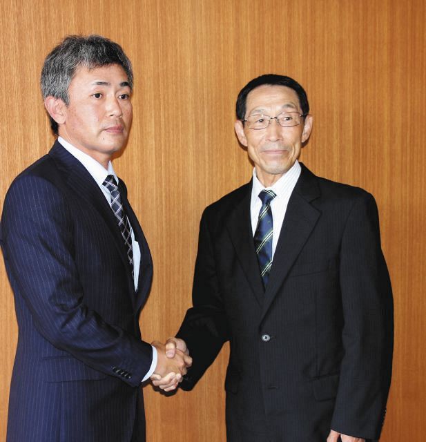 岡崎学園高の横井監督（左）と握手を交わす川口さん＝岡崎市内で