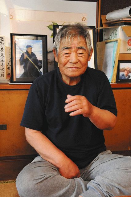兄亮一さんと一緒に漁をした思い出を語る大橋修さん。奥は亮一さんの遺影＝羽島市小熊町で 