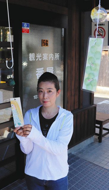 「アマビエ」を描いた短冊を持つ高橋さん=美濃市中心部のうだつの上がる町並みで