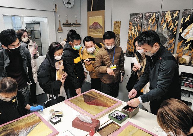 金箔の製品作りを視察する研修員ら＝金沢市打木町の箔一工場で
