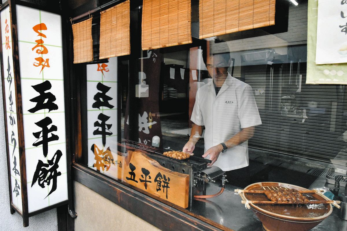ガラス越しに望む五平餅の「焼き」＝恵那市大井町のあまから恵那本店で