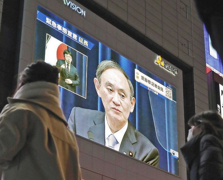 「プロンプター」を使って会見する菅首相を映す街頭モニター