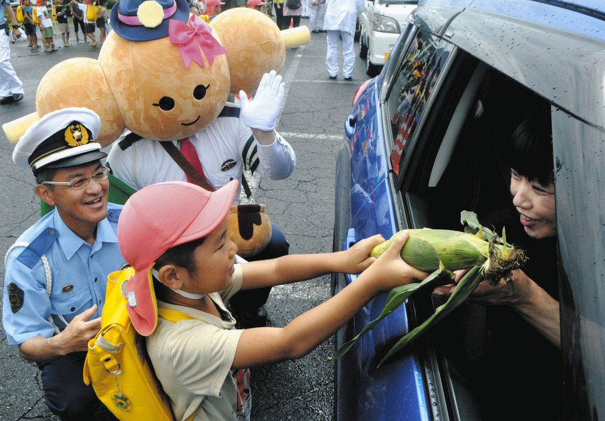 トウモロコシを運転手に贈る園児ら＝中津川市苗木で
