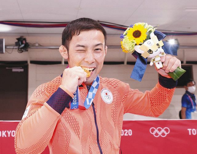 男子６０キロ級で優勝し、金メダルをかじる高藤直寿