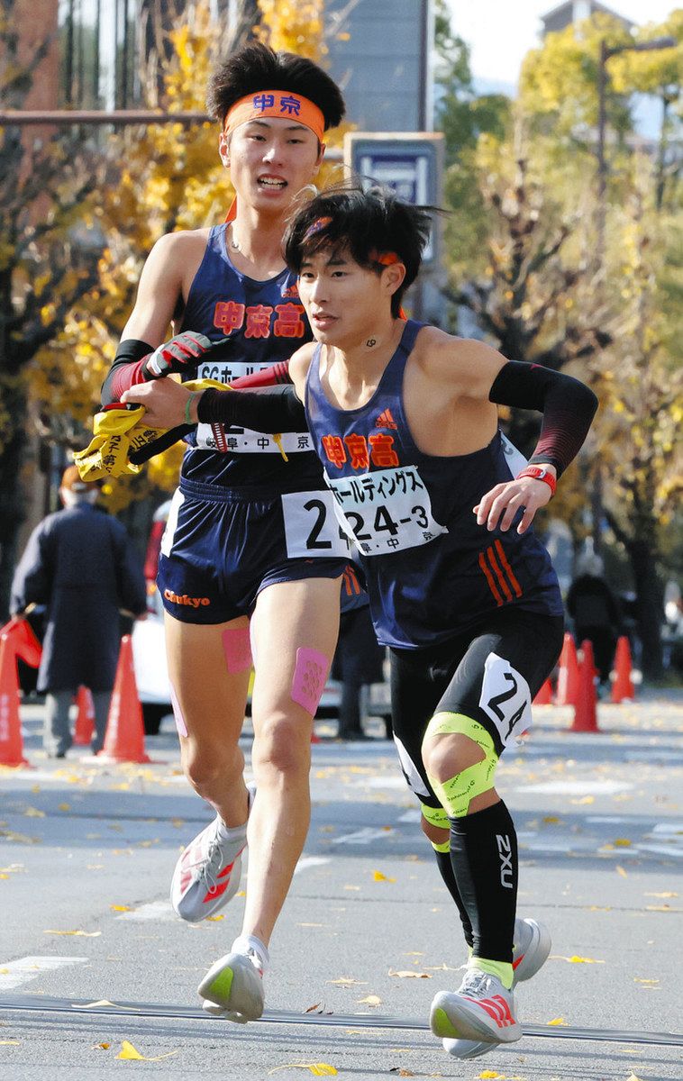 中京2区の細川選手からたすきを受け走り出す3区の山本選手＝京都市内で
