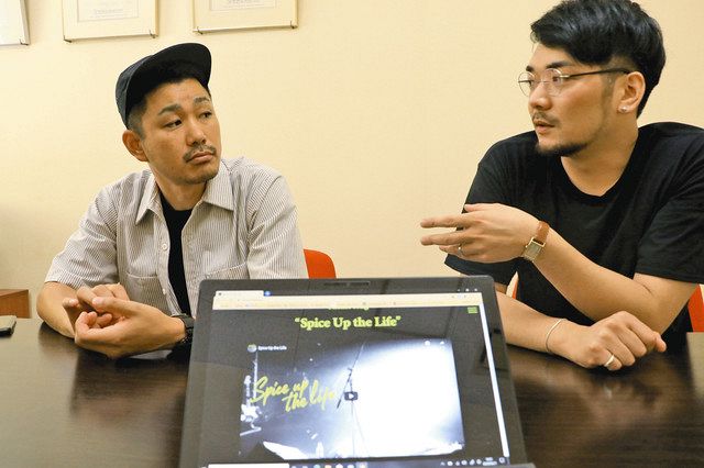 スパイス・アップ・ザ・ライフのウェブサイトの画像を前に、活動について話し合う南恵太社長（右）と００８１さん＝石川県野々市市高橋町で
