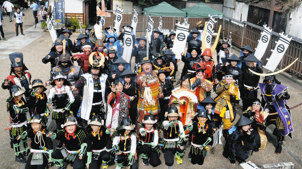 あばれる君を中心にときの声を上げる武者行列の出演者ら＝中津川市本町で
