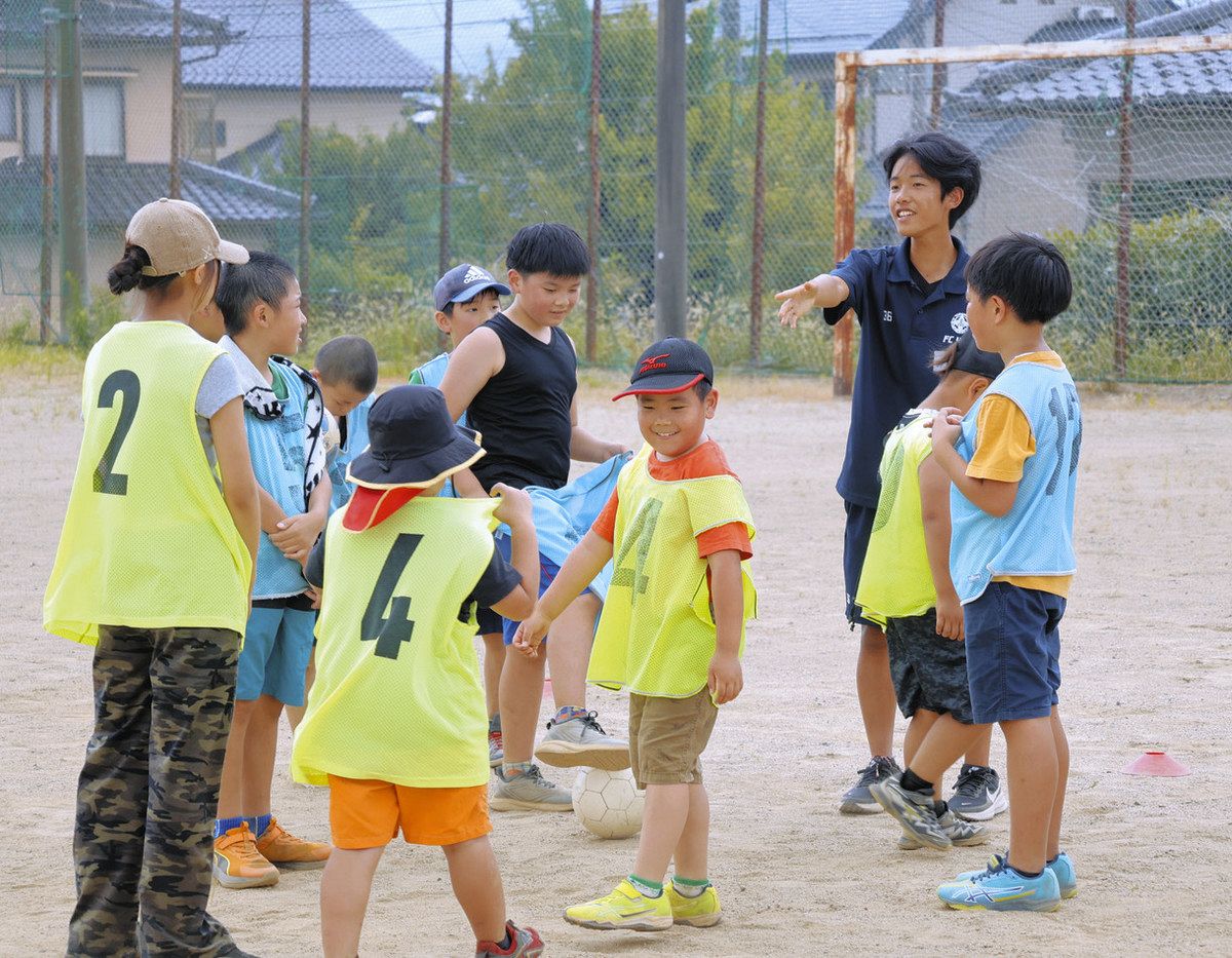 高校生からサッカーの指導を受ける小学生ら＝飯田市上郷黒田の飯田高で
